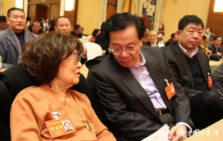 文潔若、李福明等代表在報告會前交談。