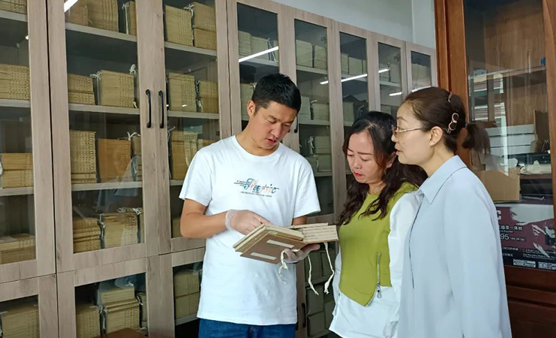 張旻（左）在大通縣圖書館了解、翻閱清代印制的經史子集典籍
