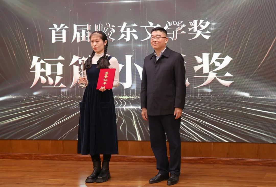 山東省作協(xié)黨組書記、副主席趙藝?。ㄓ乙唬? 為短篇小說獎獲得者王銘嬋頒獎