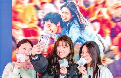 2月18日，觀眾在貴州省黔西市一家影院的電影海報前留影。 新華社發