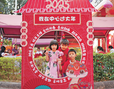 老撾民眾在“歡樂春節(jié)”廟會現(xiàn)場設(shè)立的新春祈福打卡點拍照。  坎帕頌攝