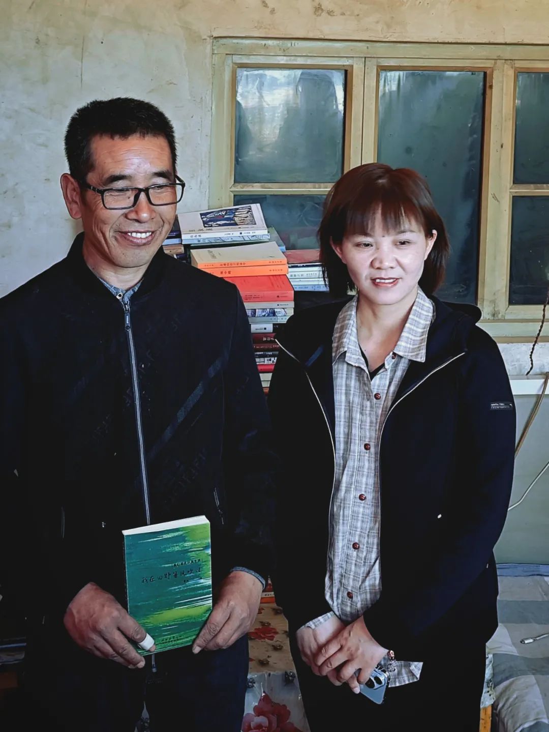 曹兵捧著自己的詩集與賀秋菊合影留念