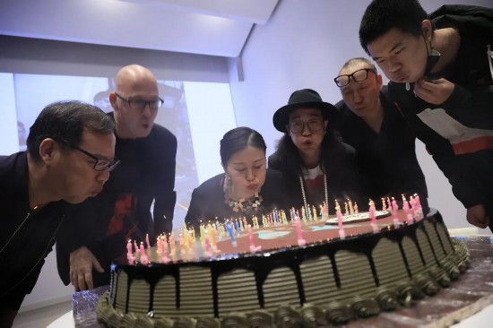 北京，“人人都是藝術家——約瑟夫·博伊斯百年誕辰紀念活動”現場，眾人切生日蛋糕為約瑟夫·博伊斯慶生。蛋糕上插了100根蠟燭